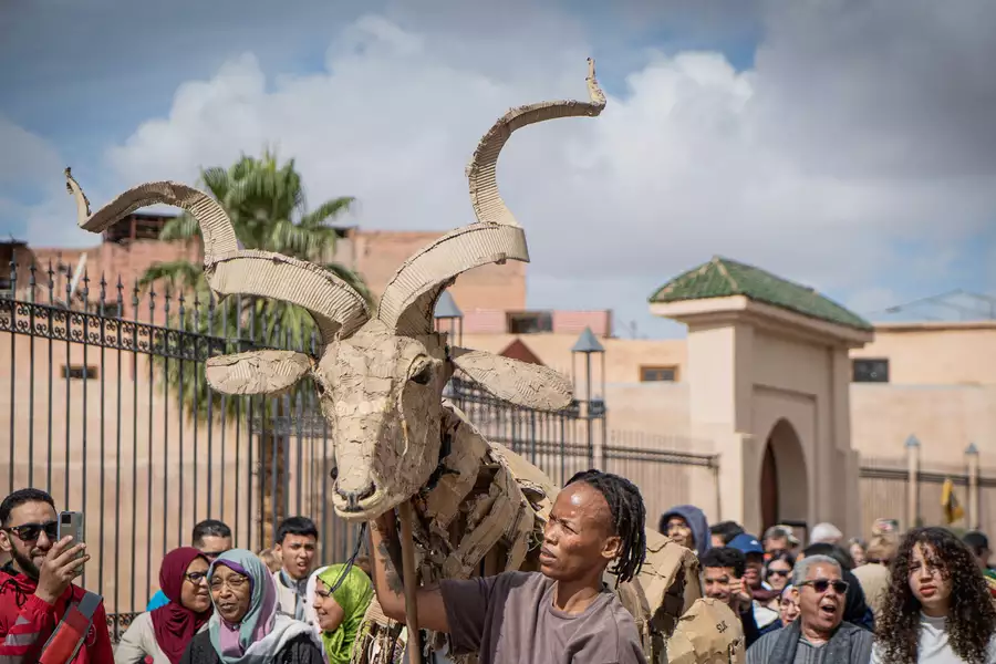 A crowd of people watching a puppet move through the Medina in Marrakesh, Morocco.