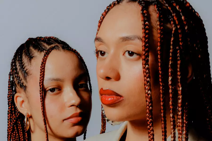 Close-up photo of two members of Shimrise with matching red and black hair