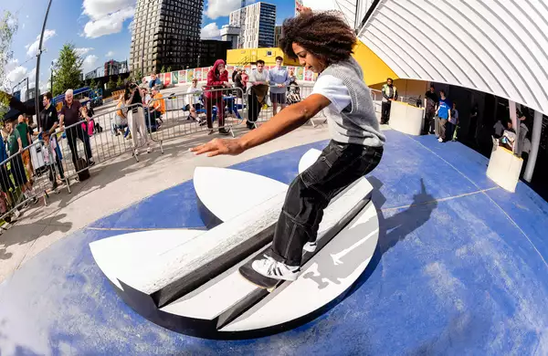 A skater outside Aviva Studios skating over an Adidas logo