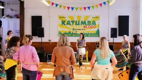 Photo of a group of people hitting drums in a circle