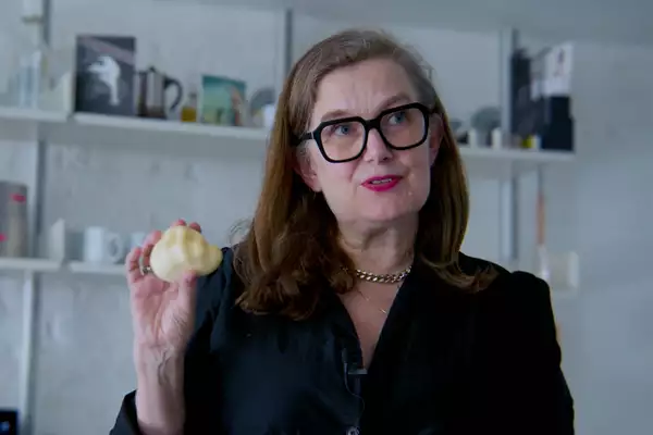 Ju from Blast Theory holding up a clay artwork in the shape of a human heart