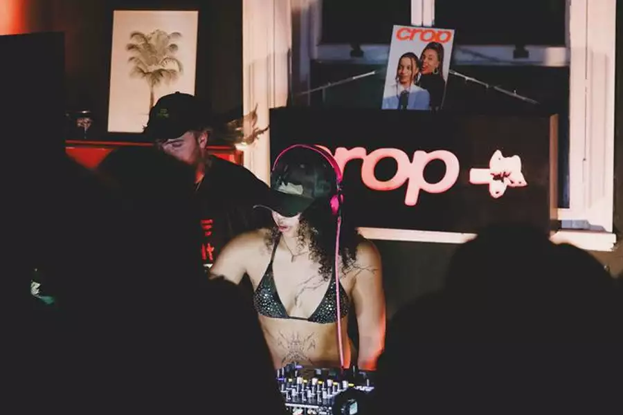 Two people DJing with the word Crop behind them