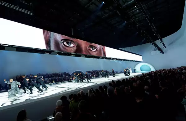 Dancers performing under a screen showing a person's eyes in Free Your Mind