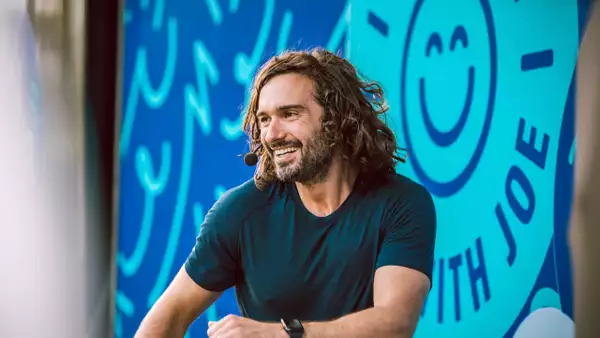Joe Wicks smiling with a microphone