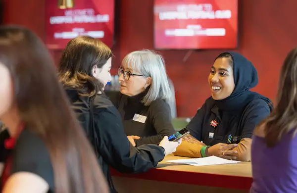 A mentor talking to a younger mentee during a speed mentoring session