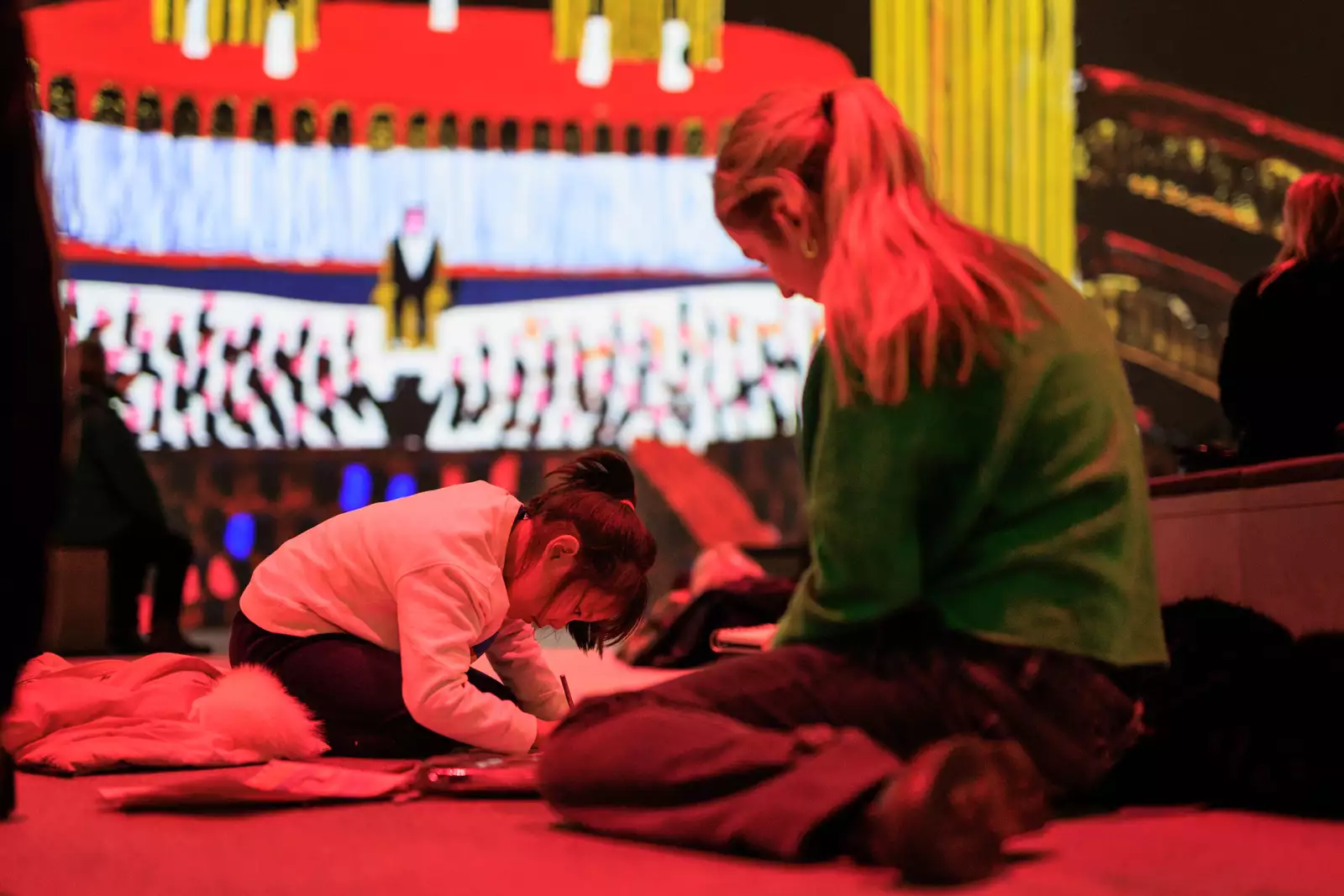 Photograph of David Hockney: Bigger & Closer (not smaller & further away) at Lightroom showing a young child colouring in a booklet with their parent