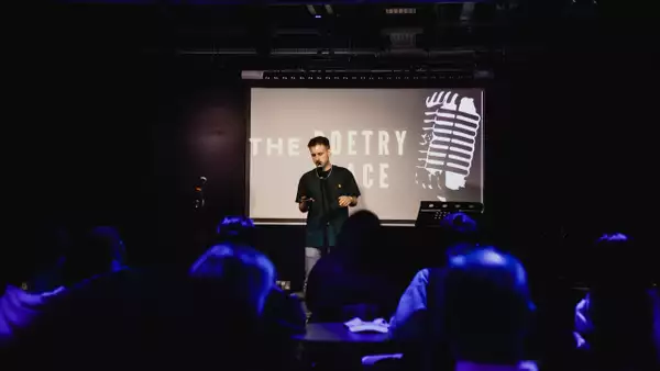 Photo of a poetry slam event with a poet on stage