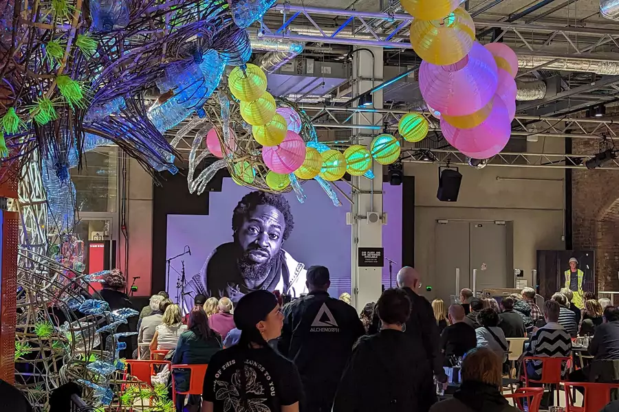 A crowd of people in the Social watching a film on stage