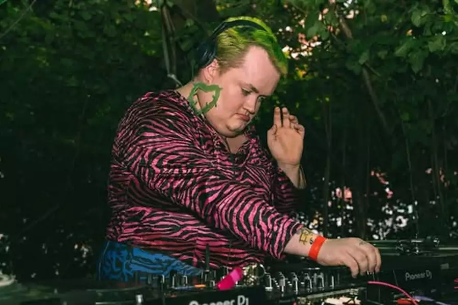 The Fat Britney DJing outside wearing a pink zebra striped top