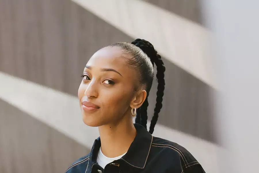 Headshot of TARZSA with hair tied up and gold hoop earrings