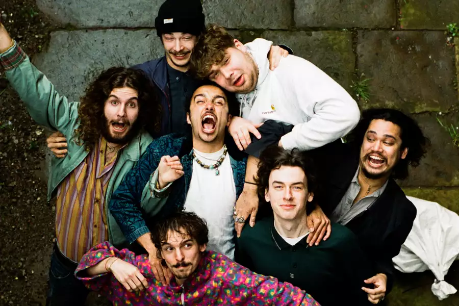 Iris stand close together on stone pavement, smiling and making playful faces at the camera.