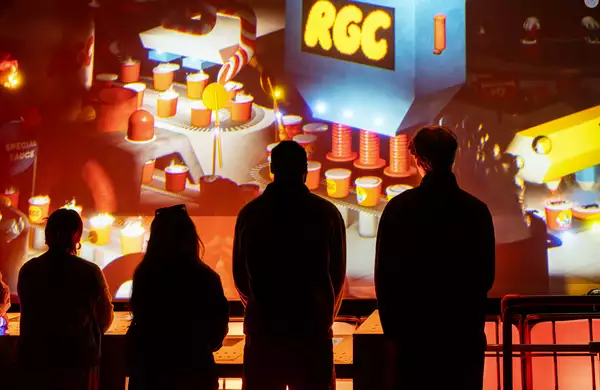 Silhouettes of people in front of a wall of digital art